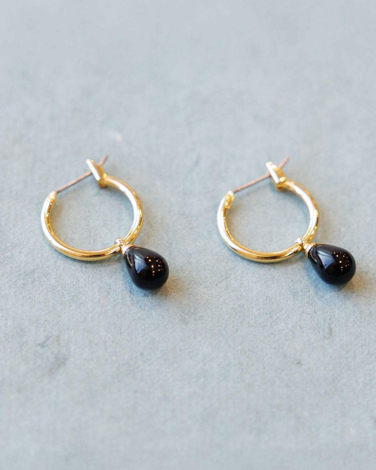 Downeast hoop and charm earrings featuring circular hoops with small hanging charms, stylish jewelry for everyday wear.