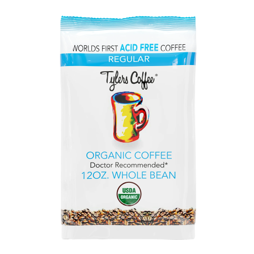 Two whole beans of Tylers Coffees regular acid-free coffee in a close-up image showing their smooth, rich brown surface.