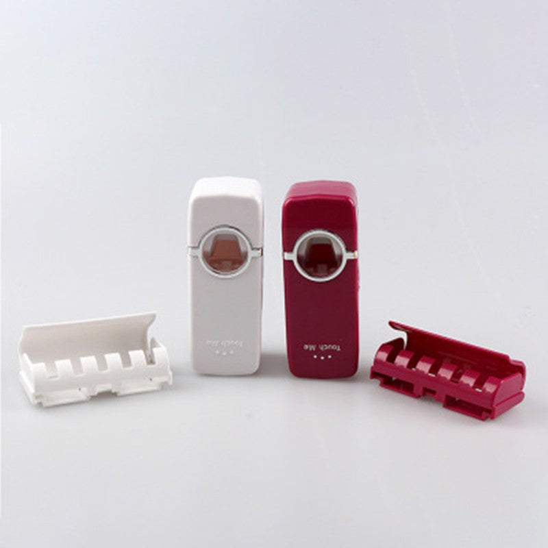 Automatic toothpaste squeezer dispenser mounted on a bathroom wall