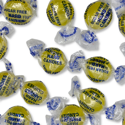 Two yellow Arcor Lemon Drops sugar-free hard candies in a bulk Candy In Bulk bag, showcasing bright lemon-flavored candy.