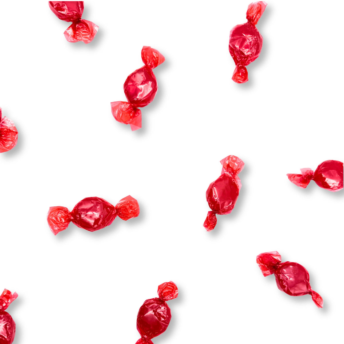 Two cinnamon hard candies from Candy In Bulk's Arcor Cinnamon Hard Candy bulk value bag, showcasing their round shape and spicy flavor.