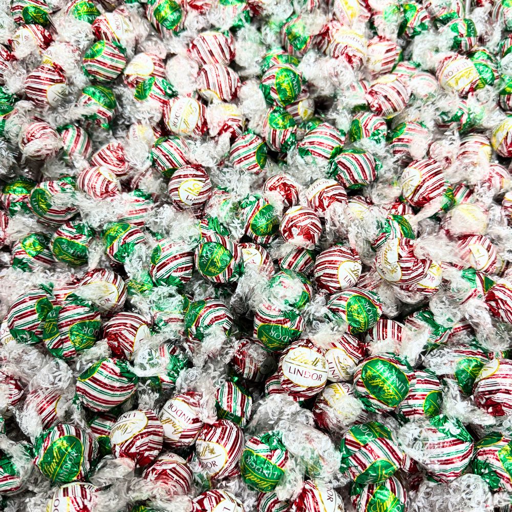 Assorted Lindt LINDOR peppermint chocolate truffles in a bulk Candy In Bulk bag, showcasing smooth chocolate shells with peppermint filling.