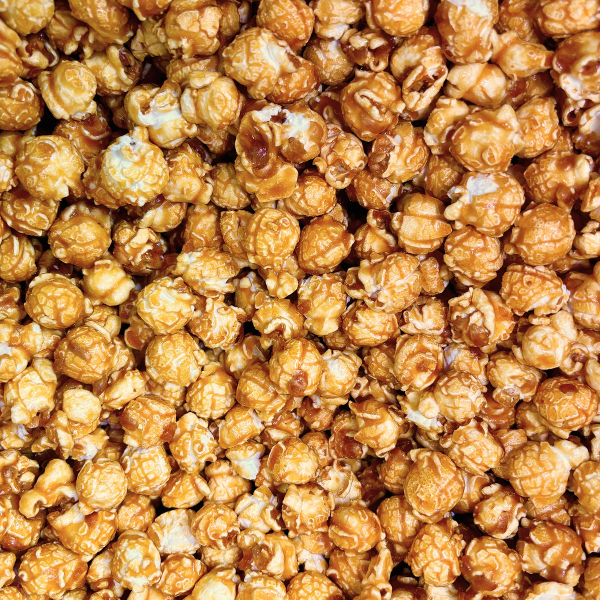 Caramel coated popcorn snack in a bulk value bag from Candy In Bulk, showing golden caramel-glazed popcorn pieces.