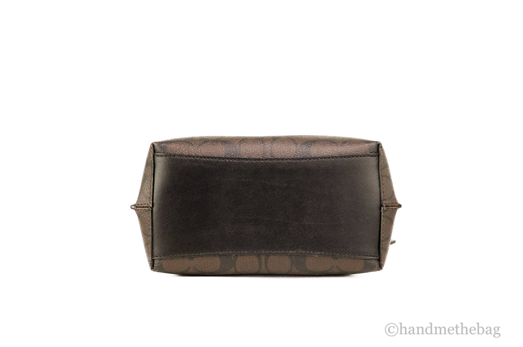 Brown and black coated canvas Coach Mollie 22 Small Bucket Crossbody Handbag with adjustable strap and metal accents.