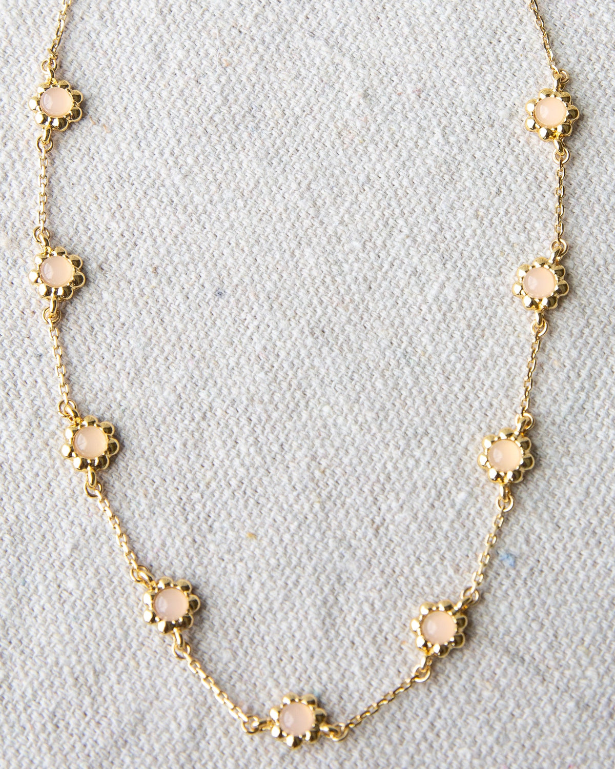 Delicate mini flower necklace from Downeast featuring a small floral pendant on a sleek chain.
