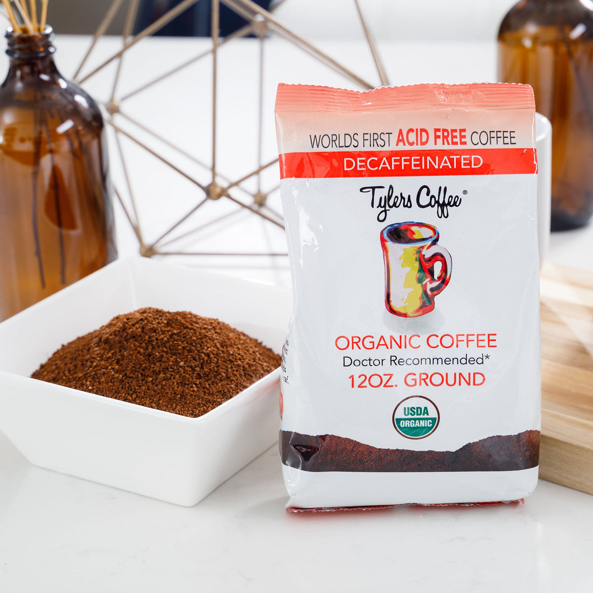Decaf acid-free ground coffee in a 12oz bag from Tylers Coffees, showing the coffee bag with branding and product label.