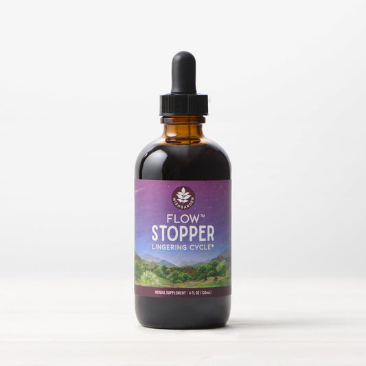 Women's Flow Stopper by WishGarden Herbs, herbal supplement for lingering menstrual cycles, in a white bottle with label.