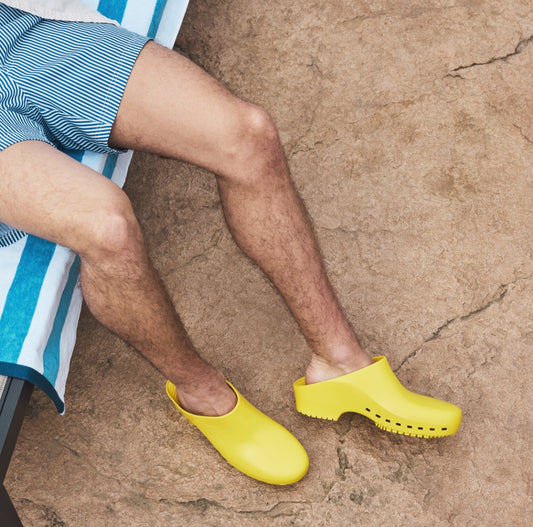 Yellow Calzuro Classic clogs without holes, made of durable material, shown in full view with a rounded toe and slip-on design.