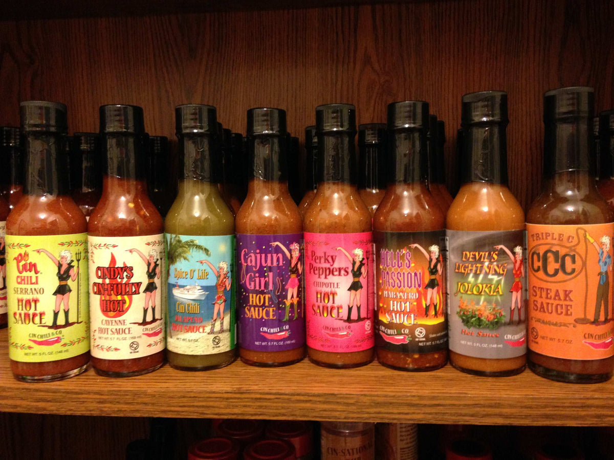 Cinderosa Ranch Bruce's Pick All 8 Hot Sauces combo set with various colorful bottles on a wooden table.