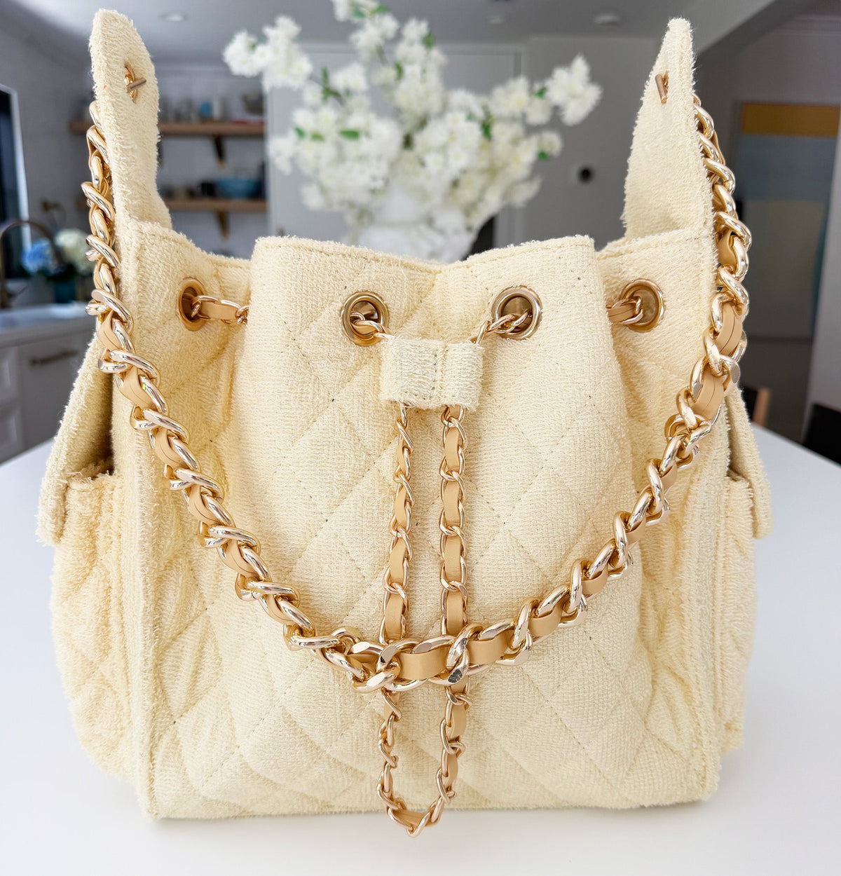 Small Bayshore Bucket Bag by BEACH HAUS in butter yellow, showcasing the woven straw design and adjustable shoulder strap.