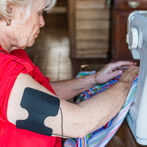 iReliev Wired Super Pads Refill Kit with replacement pads for TENS and EMS pain relief devices, shown in a lifestyle setting