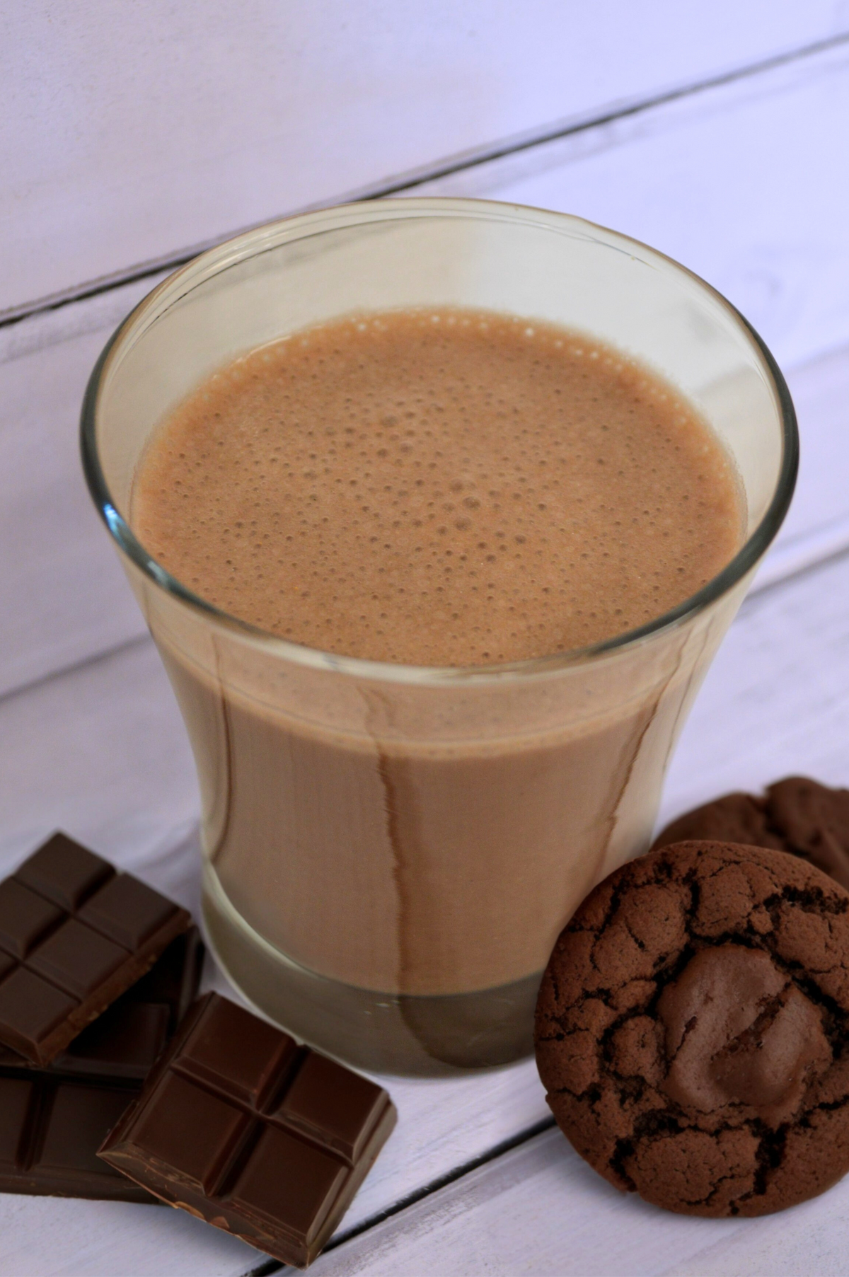 Creamy milk chocolate shake from AmBari Nutrition, featuring a rich, smooth beverage in a glass with chocolate pieces.