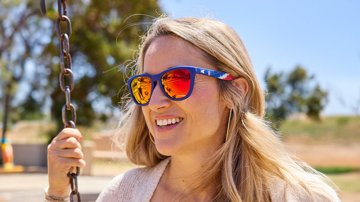 Female wearing U.S. Soccer 2024 Knockaround sunglasses by Goal Five, showcasing stylish lifestyle sunglasses with team logo.