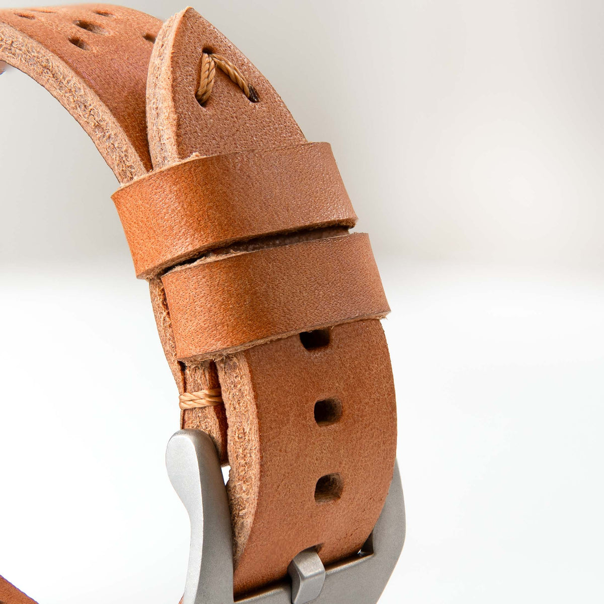 Robust racing leather strap in tan color, featuring sturdy stitching and adjustable buckle for a stylish racing-inspired accessory.