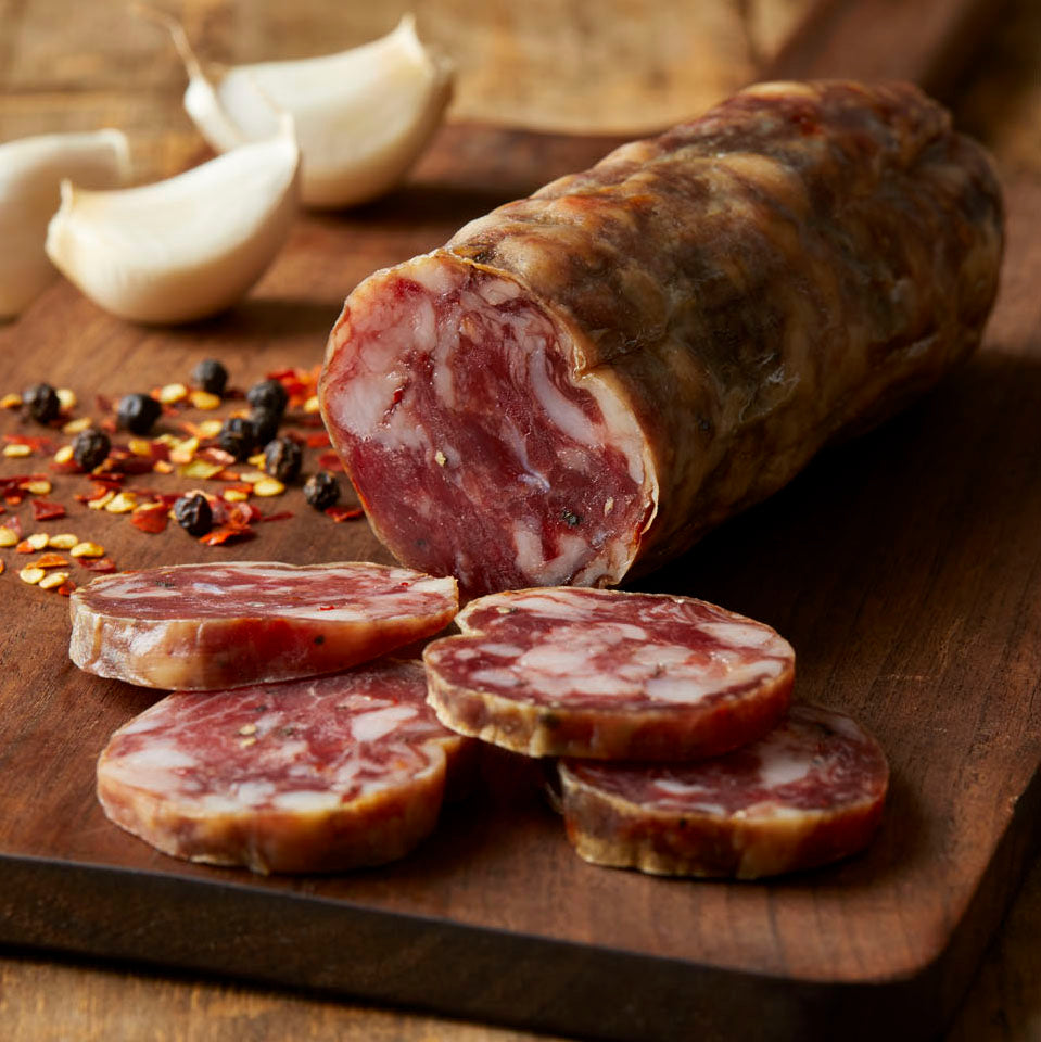 Gastros Craft Meats signature set with red wine and garlic, featuring four pieces of flavorful cured meats on a wooden board.
