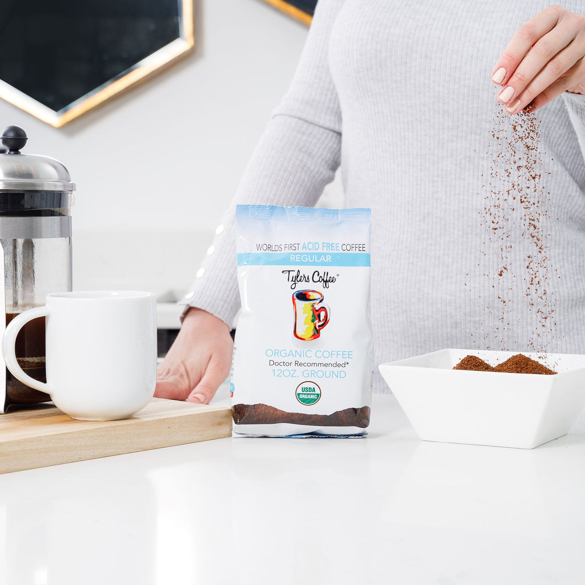 Ground acid-free coffee in a 12oz bag from Tylers Coffees, featuring a sealed bag of regular ground coffee for brewing.