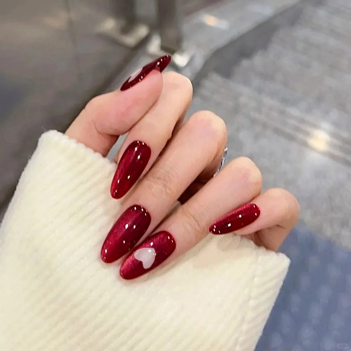 Set of 24 glossy red cat's eye press-on almond nails by Blushimmer, featuring nude color and charming detachable design.