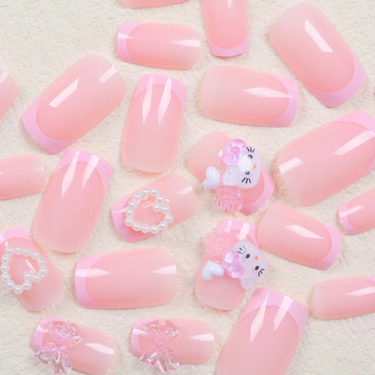Pink French cartoon cat nail patch set by Blushimmer featuring medium square nails with cute cat and bow designs.
