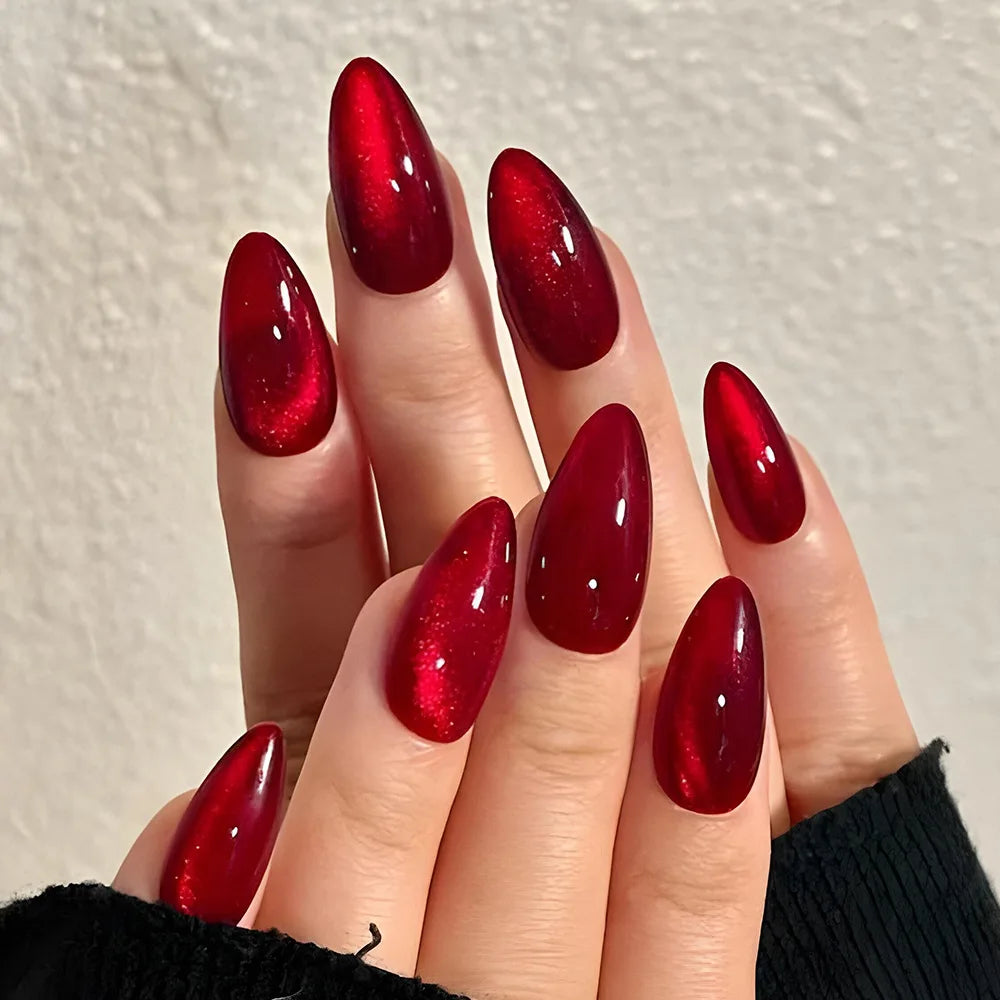 Set of 24 glossy red cat's eye press-on almond nails in nude color with charms, designed for easy wear and removal by girls.