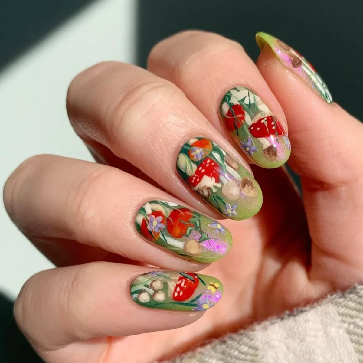 Set of 24 glossy almond false nails by Blushimmer featuring dark green forest and mushroom pattern with gold sequins in French style design.