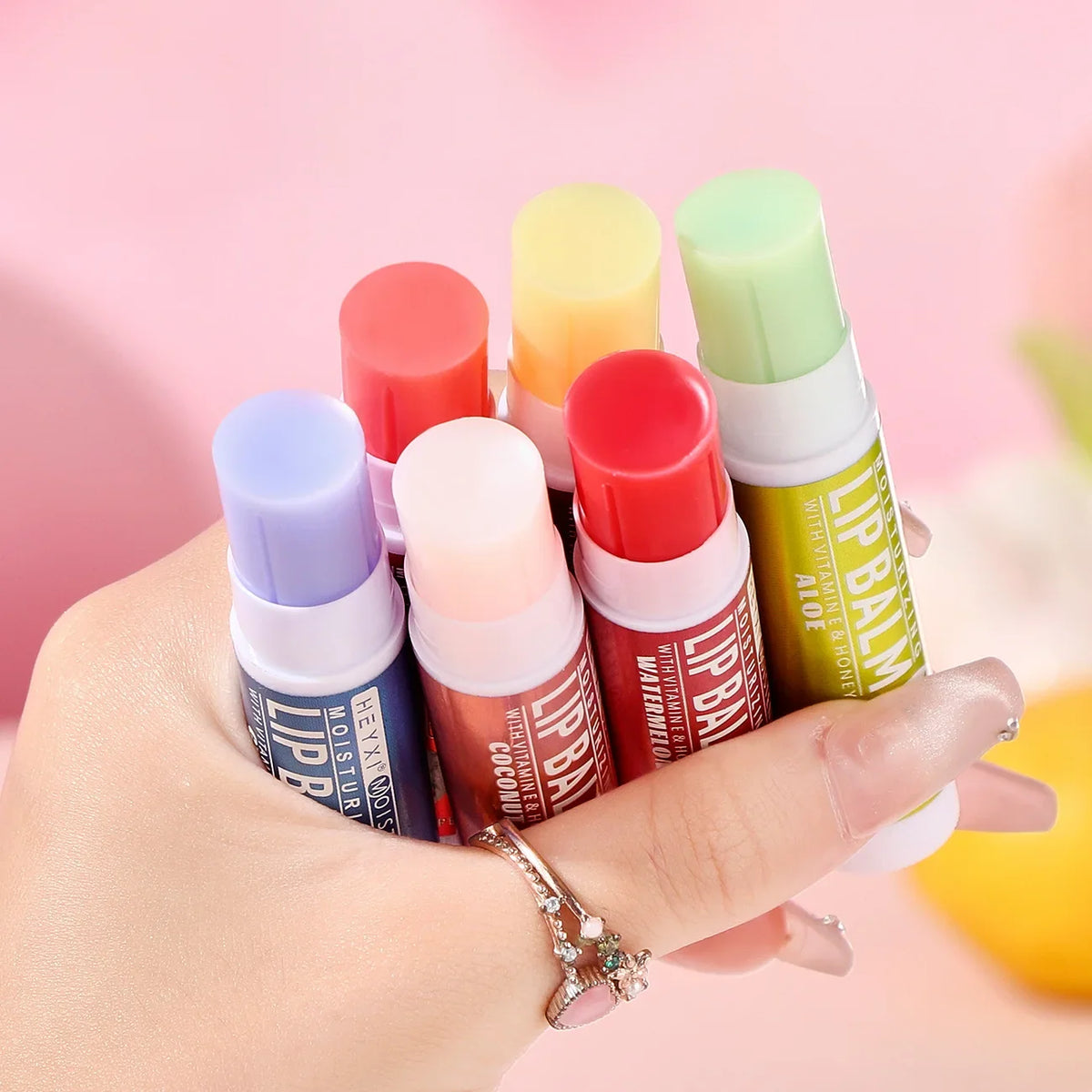 Set of 24 Blushimmer fruit-flavored lip balms featuring natural, moisturizing, hydrating, non-sticky formulas for soft, healthy lips.