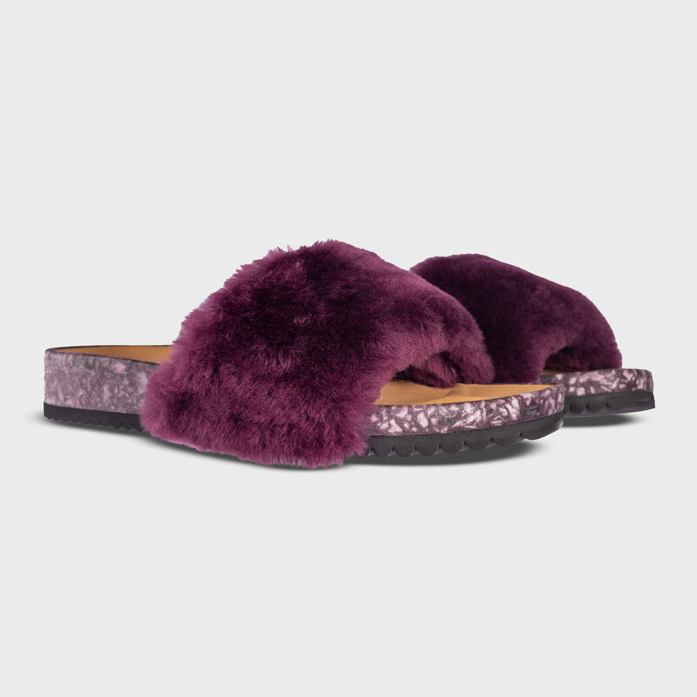 Fleks San Ysidro Slide in Fig color, featuring a stylish slip-on design with a comfortable sole, shown from an angled side view.