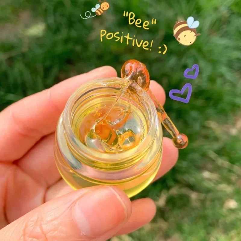 Blushimmer transparent honey pot lip mask for moisturizing, lightening lip lines, and lip care, shown in a clear jar.