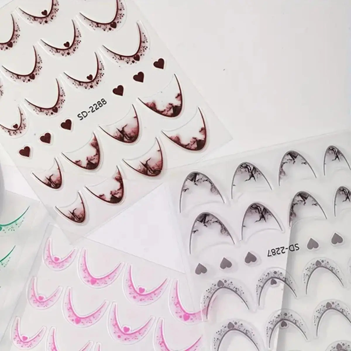 Set of 12 Blushimmer French tip nail stickers with gradient and heart designs, self-adhesive manicure decals in 12 colors for DIY nails.