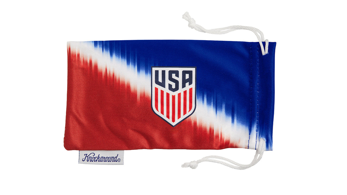 U.S. Soccer 2024 Knockaround sunglasses in a lifestyle setting, with a pouch, showcasing stylish, affordable eyewear by Goal Five.