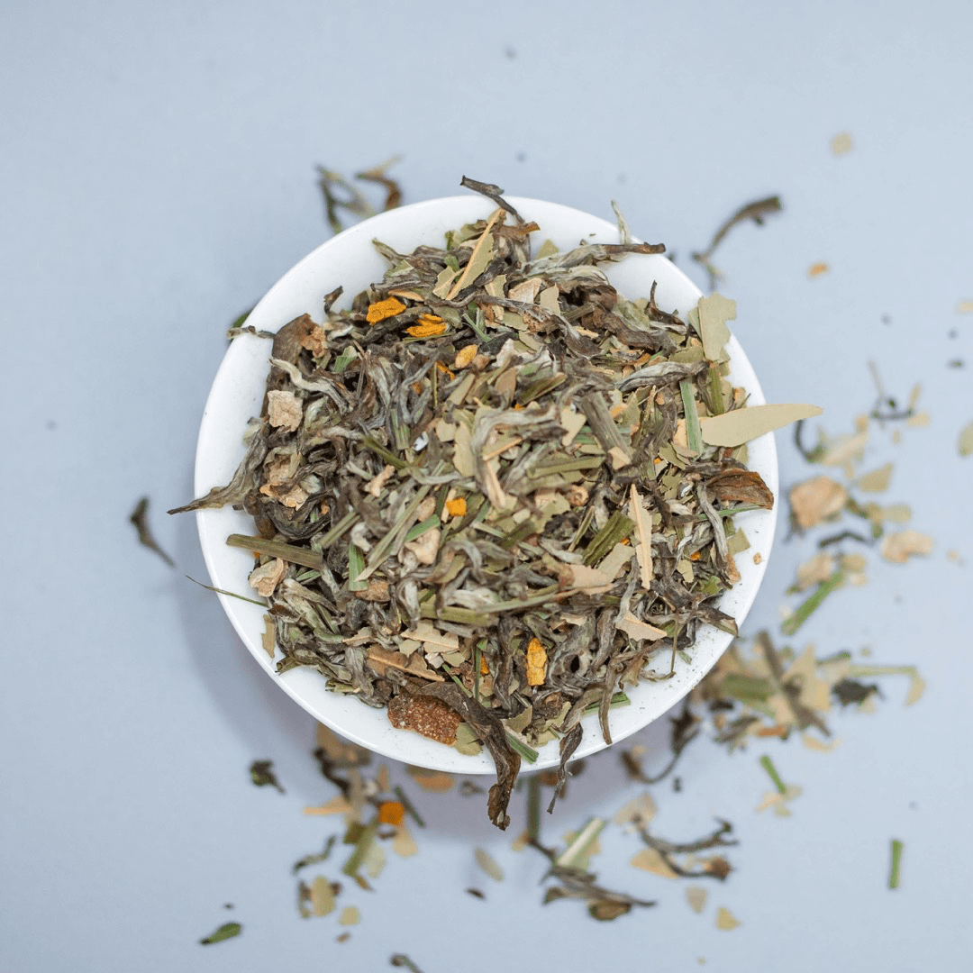 Organic Buddha's Potion blend by Nepal Tea, featuring a vibrant herbal infusion with fresh organic herbs and flowers in a glass jar.