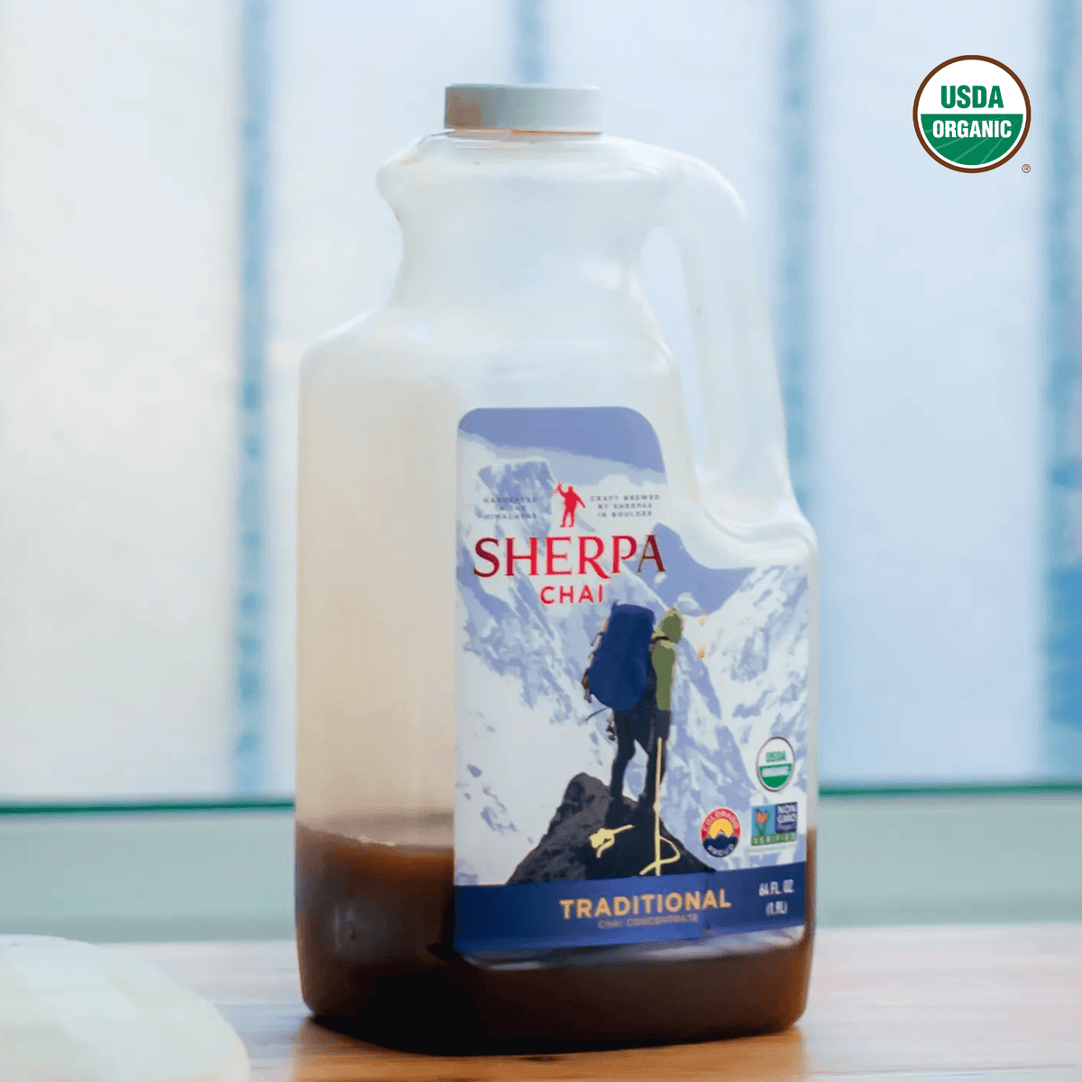 Bottle of Sherpa Chai Chai Concentrate by Nepal Tea, showcasing the beverage's rich, spiced chai flavor in a clear glass bottle.