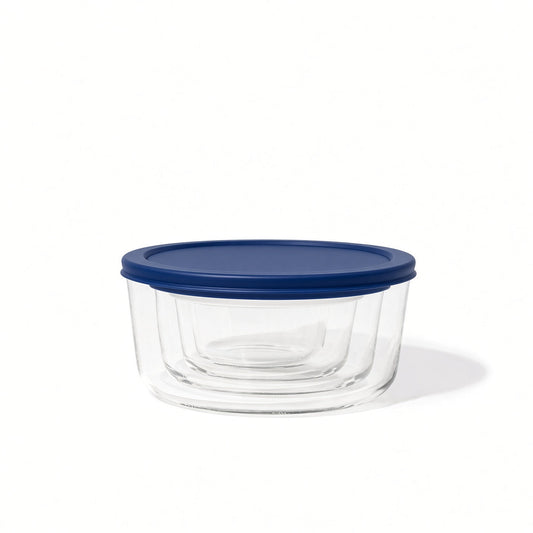Set of four round glass storage containers with blue lids, nesting for easy storage, by Dura Living, ideal for kitchen organization.