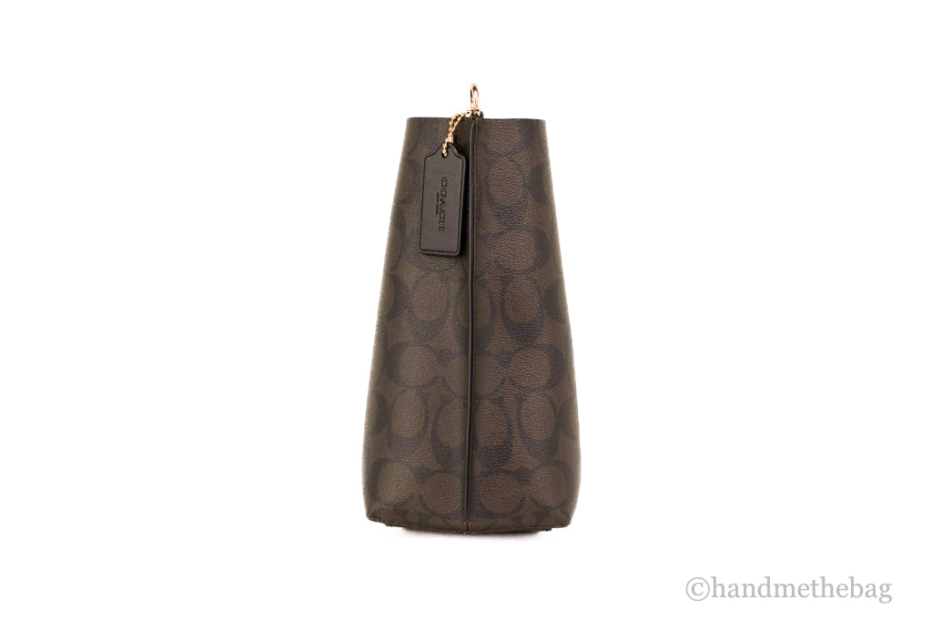 Coach Mollie 22 small brown and black coated canvas bucket crossbody handbag with adjustable strap and minimalist design.