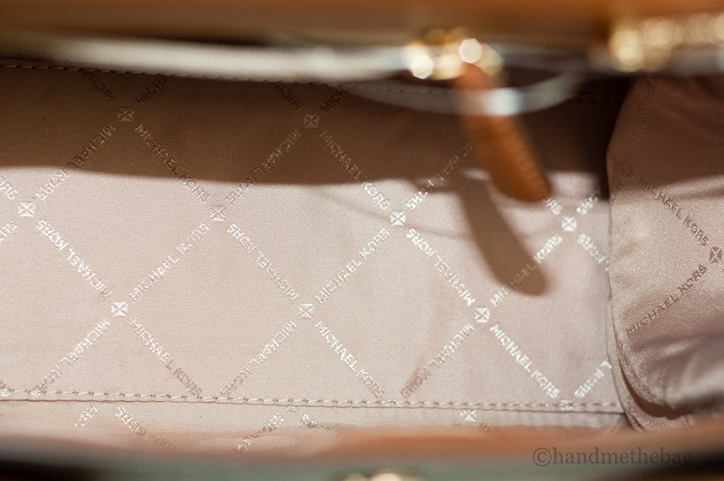 Michael Kors Carmen Signature Brown Satchel showing textured leather, double handles, and gold-tone hardware for stylish carry.