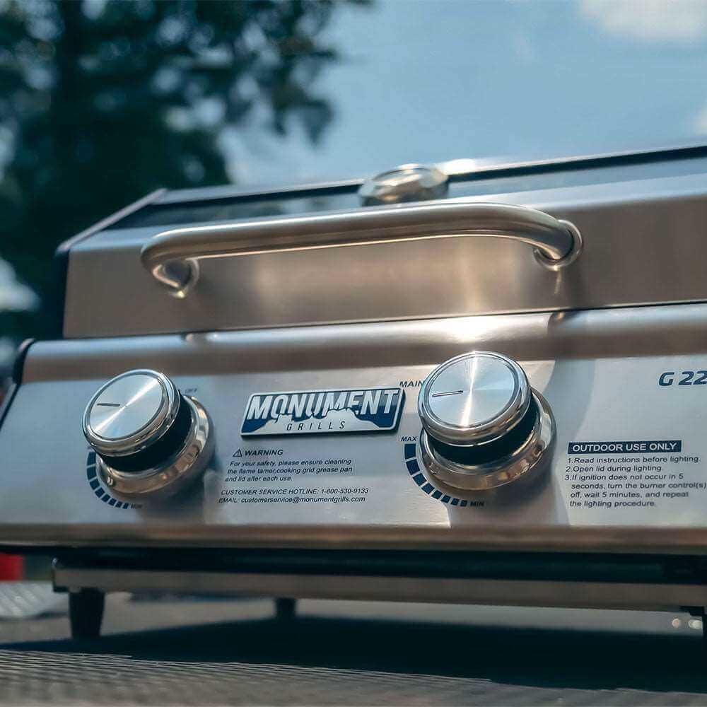 Stainless G22 tabletop propane gas grill by Monument Grills with cooking grates and control knobs.