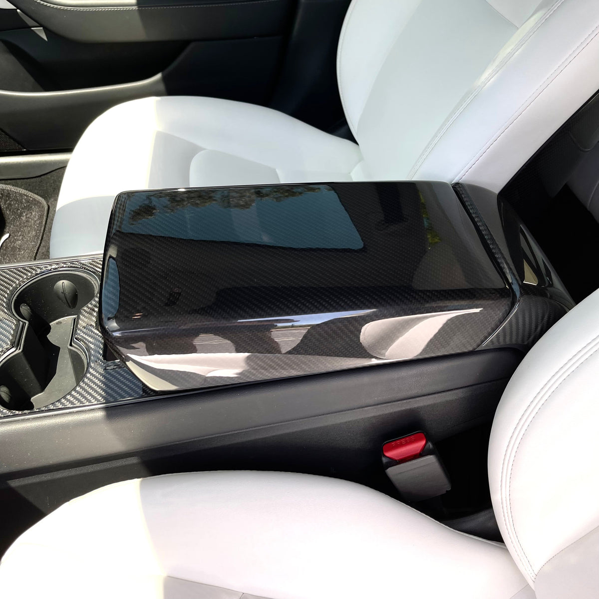 Tesla Model Y armrest cover in dry carbon fiber with sleek interior modification, designed by Tesery for a stylish upgrade.