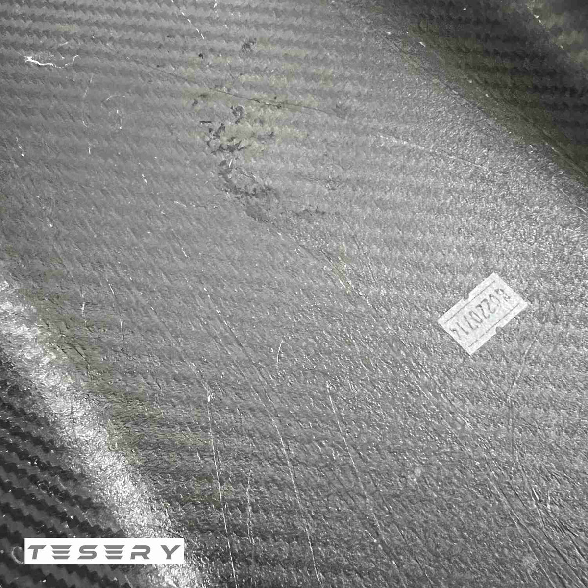 Tesla Model Y and 3 armrest cover made of dry carbon fiber, interior modification by TESERY with sleek, textured material.