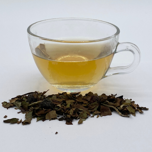 White blueberry loose leaf white tea in a clear glass jar, showcasing fresh tea leaves and dried blueberries for tea lovers.