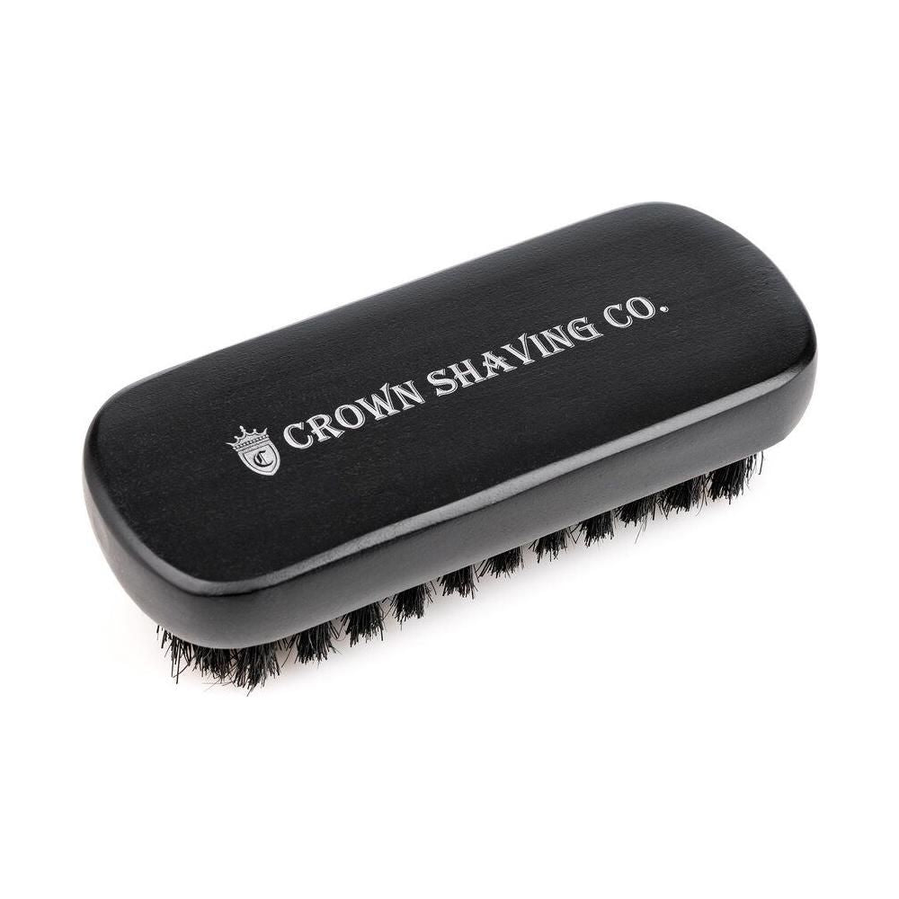 Crown Shaving Co. beard brush with wooden handle and natural bristles for grooming and styling facial hair.