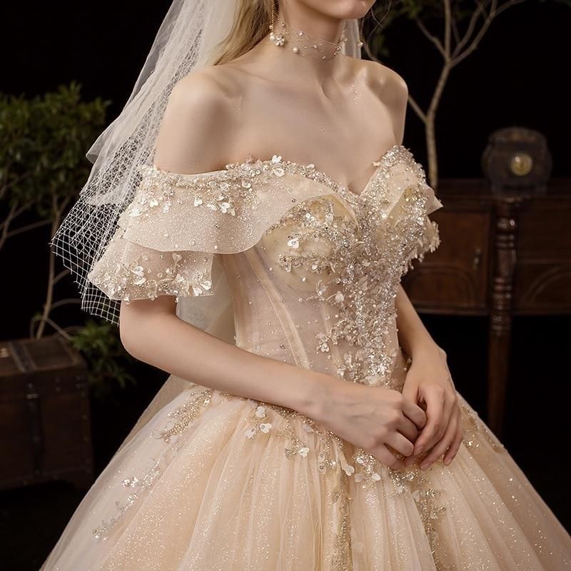 Shiny vintage off-shoulder wedding dress with crystal bead embellishments, luxurious gown by EdleessFashion.