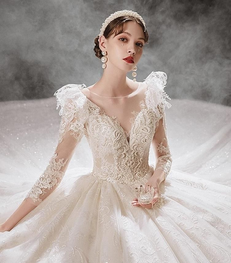 Luxurious princess wedding gown by EdleessFashion with shiny pearls, intricate lace details, and flowing train for a fairy-tale bridal look.