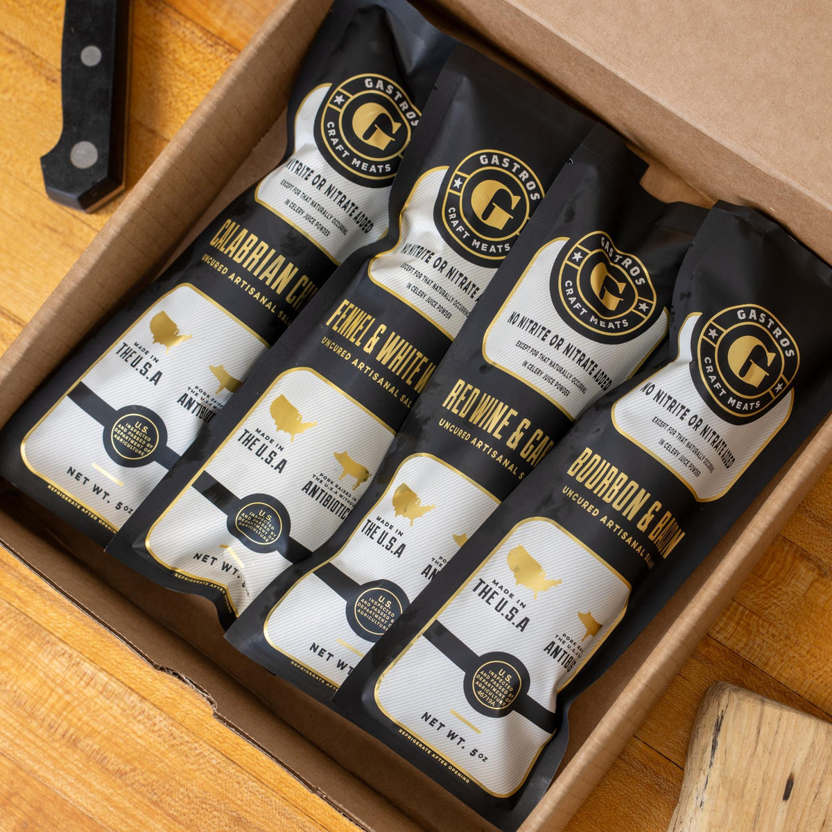 Gastros Craft Meats Signature Set with four pieces of artisanal meat products arranged on a wooden board.
