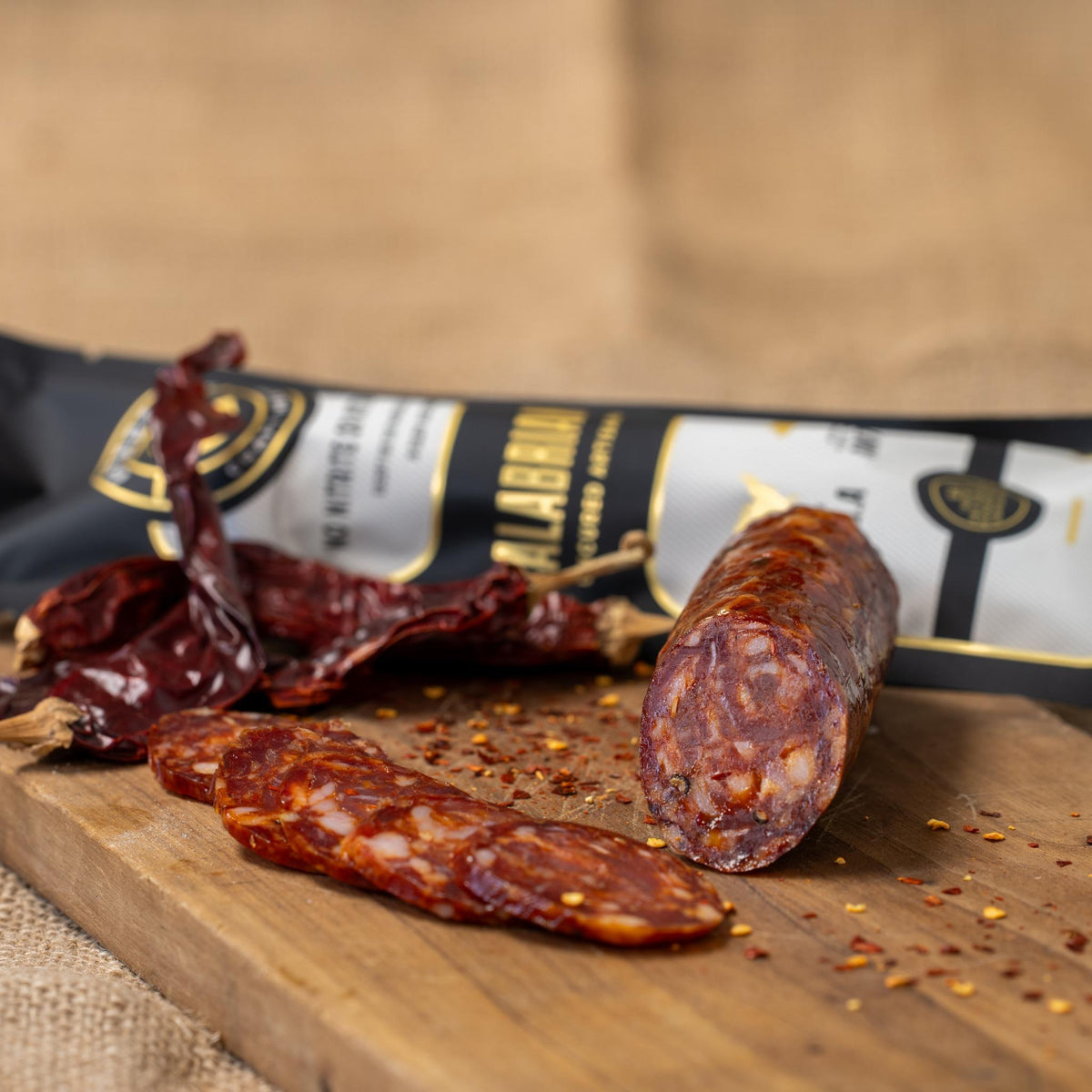 Spicy Calabrian chili peppers from Gastros Craft Meats in a jar, showcasing vibrant red chili peppers ready for cooking or garnishing.