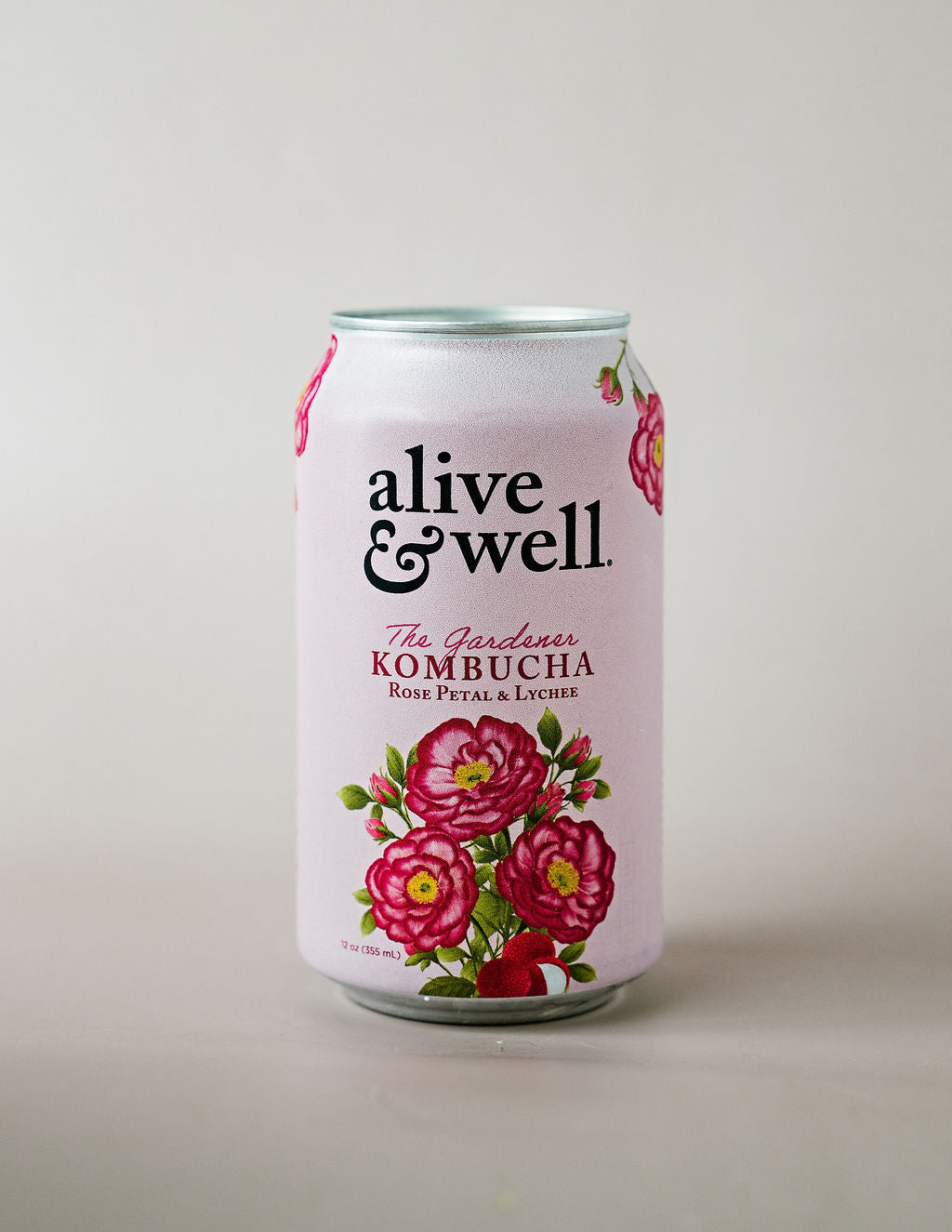 Six cans of Alive & Well Organic Rose Petal & Lychee Kombucha featuring floral rose petals and lychee fruit on the label.