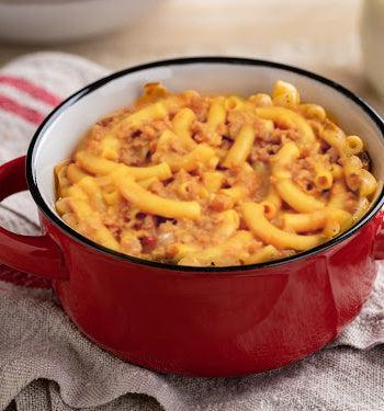 Spicy cheesy pasta from AmBari Nutrition featuring melted cheese, pasta noodles, and a spicy sauce in a bowl.
