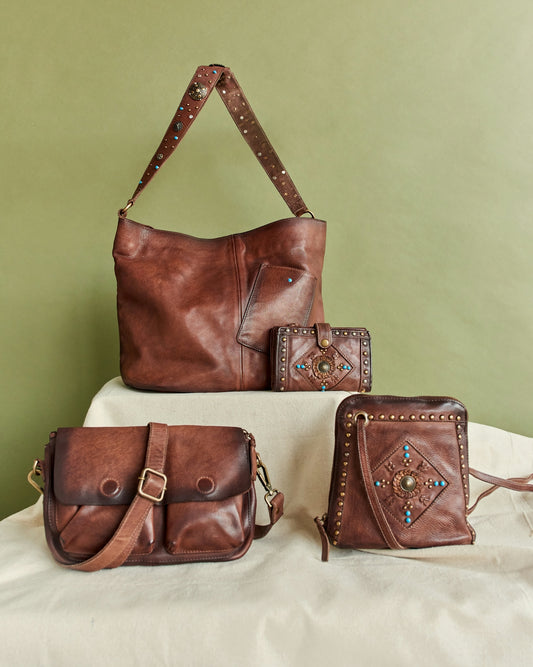 Four brown leather bags and wallets arranged artfully