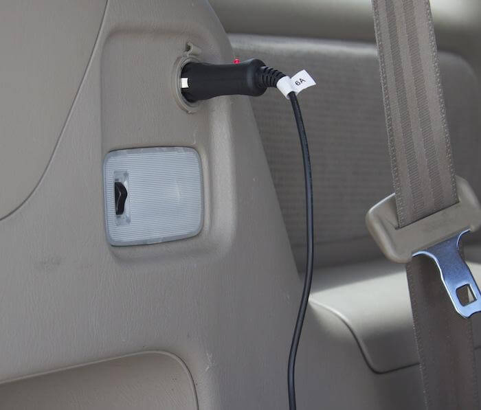 Naxa 12 Volt DC power cord with cigarette lighter socket, universal connector for TVs, shown connected to a vehicle power outlet.