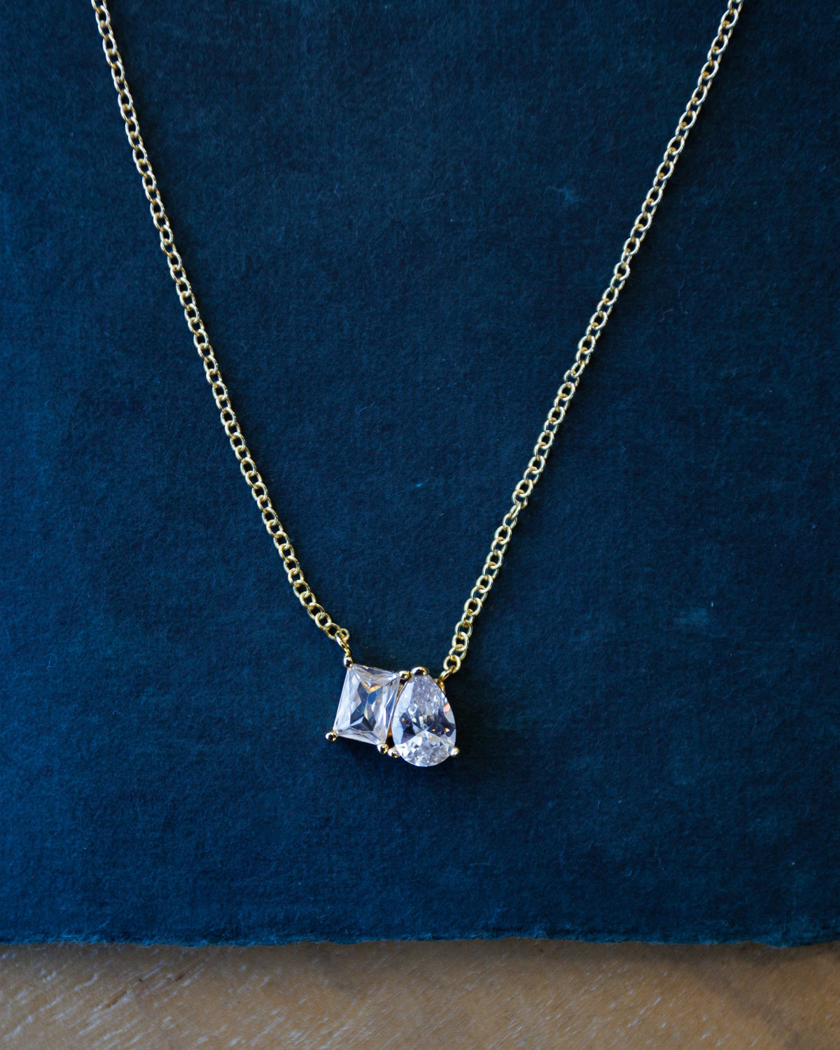 Downeast C'Est Bon Necklace featuring a delicate chain and pendant with elegant lettering, displayed against a neutral background.