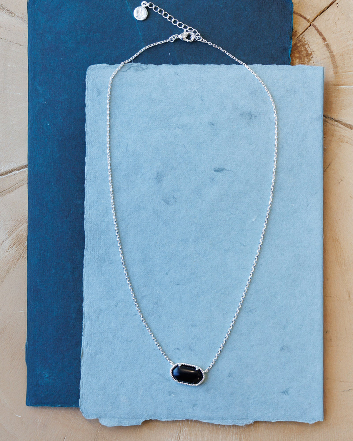 Silver quartz pendant necklace from Downeast featuring a polished silver chain and a prominent teardrop-shaped quartz pendant.