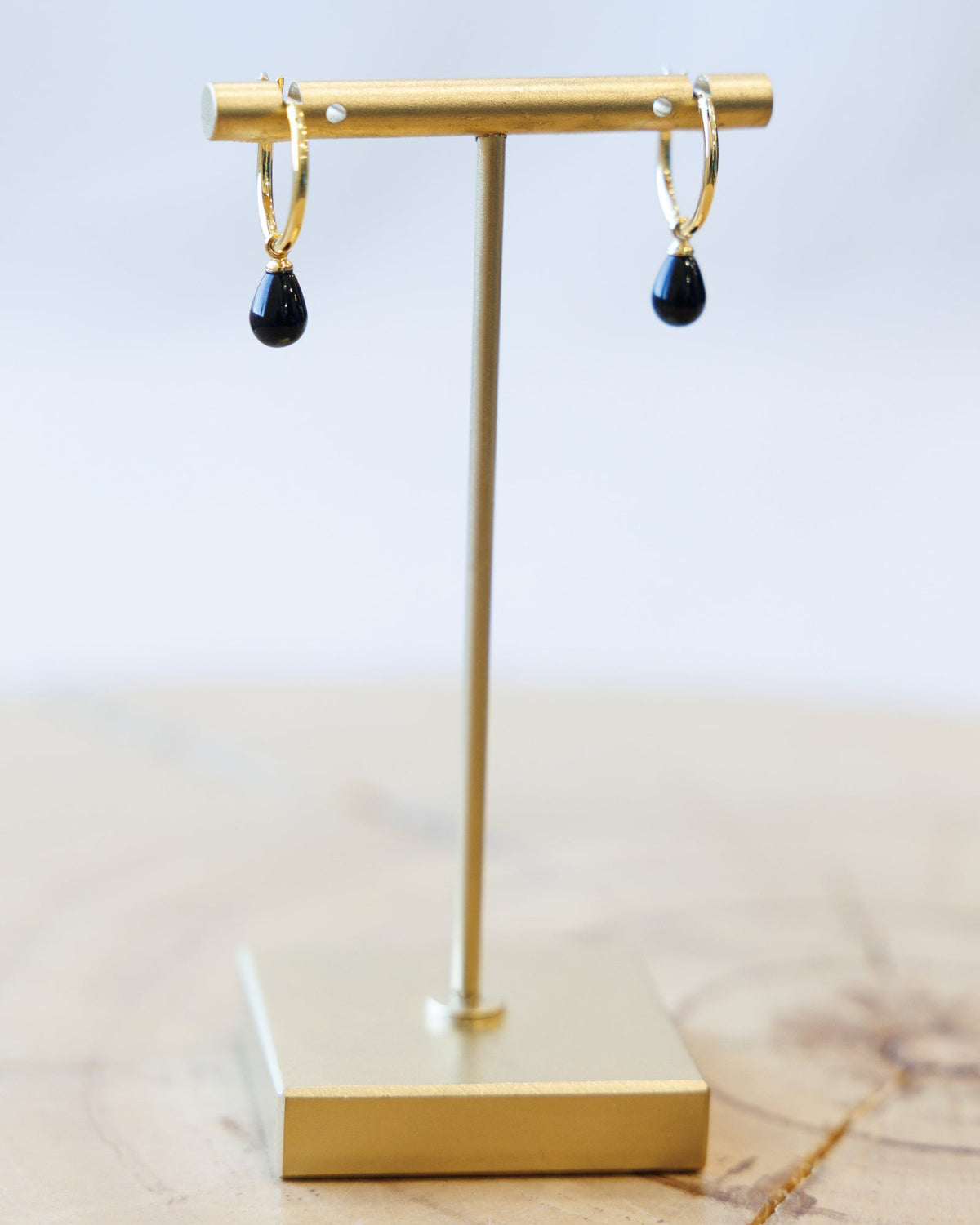 Downeast hoop and charm earrings featuring metal hoops with decorative charms, stylish jewelry for versatile wear.